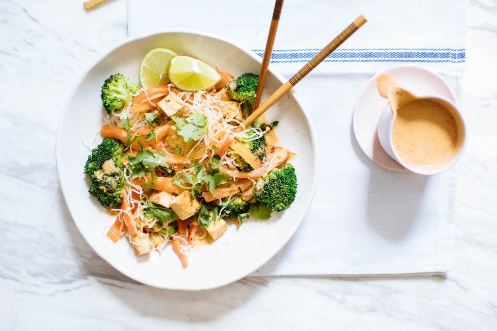 Bol nourrissant de nouilles de riz aux légumes avec sauce aux arachides