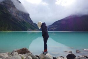 Woman stands on the shore of Lake Louise